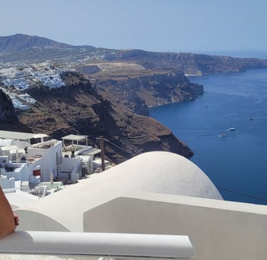 a french sommeliere standing on a balcony at santorini