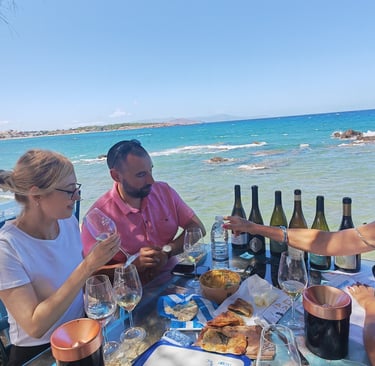 a group of people sitting at a table with greek wine during wine tasting
