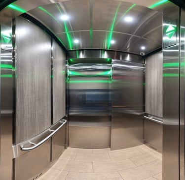elevator interior, stainless steel on ceiling and front wall, light wood panel walls and tile floor