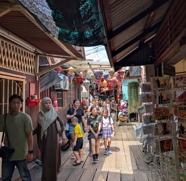 Tourists walk through a narrow street market at the historic Chew Jetty in Penang, Malaysia.