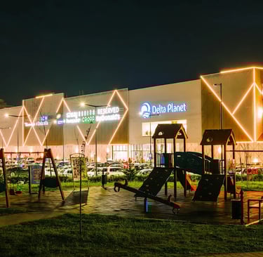 Delta Planet Mall in Nis, Serbia illuminated by neon lights at night.