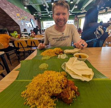 Don enjoying a traditional South Indian biryani meal served on a banana leaf in a busy restaurant.