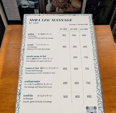 A Mira Lek Massage menu listing prices for Thai massage, foot massage, and oil massage services in Thai Baht.