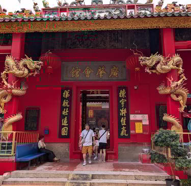 Ornate entrance of Guan Di temple in Kuala Lumpur with golden dragons and guardian statues.