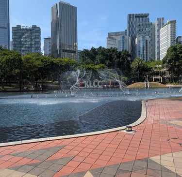 Symphony Lake fountain at KLCC Park with Kuala Lumpur city skyscrapers in the background.