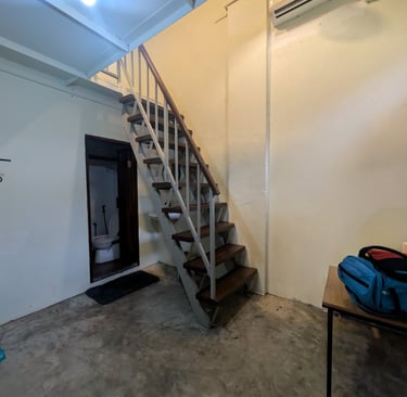 Industrial style interior featuring open-tread stairs, concrete floor, and air conditioning unit.