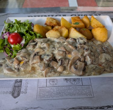 Delicious chicken smothered in mushoom, cheese with roasted potatoes, salad called Novi Sad Chicken 