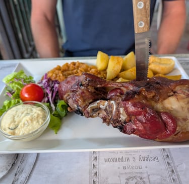 Roasted prk shank with potatoes and salad with a side of horses radish in Novi Sad, Serbia