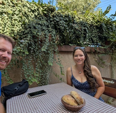 Don and Samantha eatting lunch at an outdoor table with ivy in Belgrade Serbia 