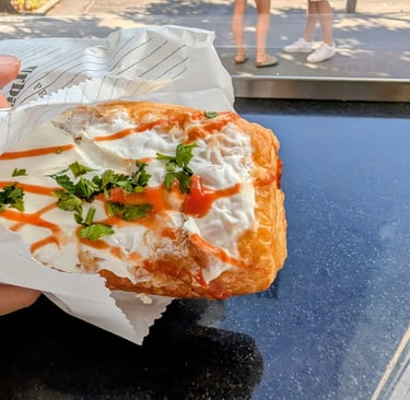 Pizza pastry filled with cured meats, tomaroes sause and cheese and topped with sour cream Belgrade