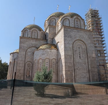 Church of Saints Constantine and Helena with gold domes, and a bell tower under construction.