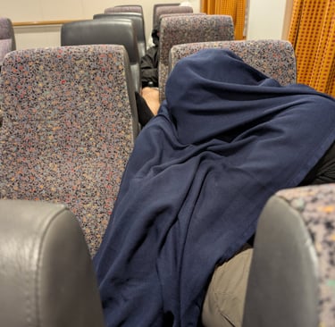 don sleeping under a blanket on the Blue star ferry from Thessaloniki to Lesbos Greece