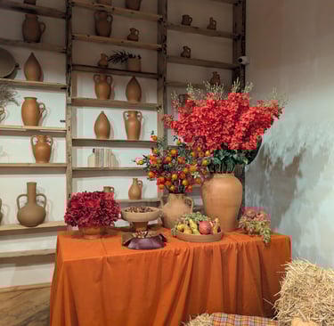 A wall with clay pots and a table with clay pots and flowers at Gala in Kutaisi Georgia