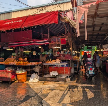 Kholong Toei market in Thailand with street food vendors, local meat, and motorbikes.