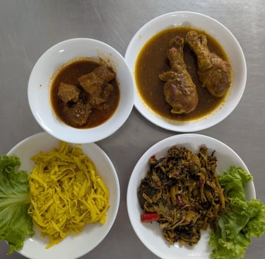 Variety of Burmese dishes including chicken drumstick curry, pork stew, and pickled bamboo shoots.