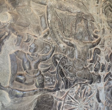 carved warriors on a large stone wall panel at Angkor Wat, Cambodia