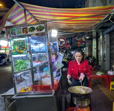 a street food vendor stir frying frog in Phnom Penh, Cambodia