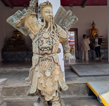 An ancient stone Chinese guardian statue at Wat Pho temple in Bangkok, Thailand.