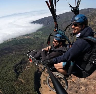 Dos personas sonriendo practican parapente adaptado en Tenerife