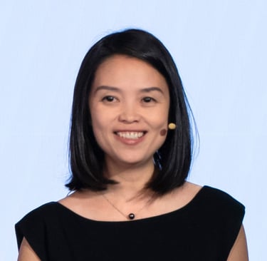 a woman in a black dress smiling with a microphone