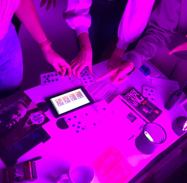 Friends solve puzzles at an immersive escape room table illuminated by neon purple light.