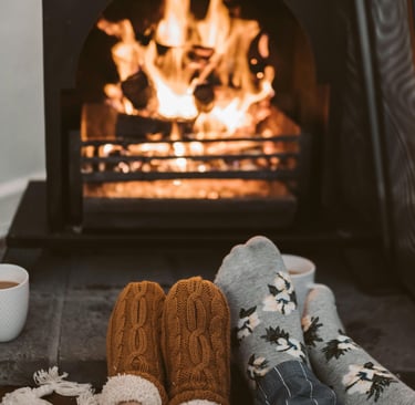A cozy living room with a warm fireplace, thick blankets, and energy-efficient space heaters,