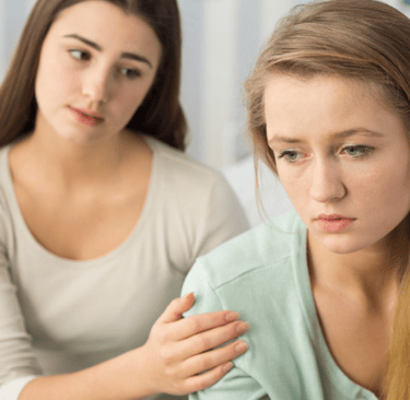 Deux jeunes femmes, l'une semblant éprouver un mal-être, illustrant la blessure d'humiliation