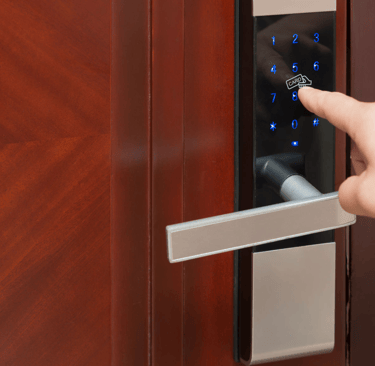a person's hand is pressing a keypad on a door