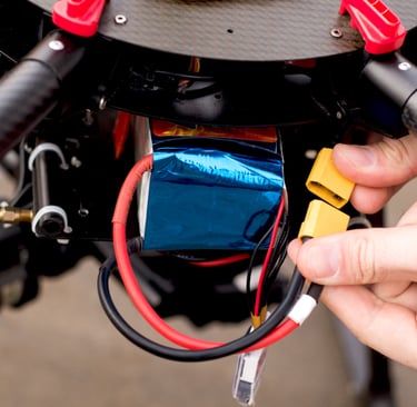 a person holding a small battery in their hand