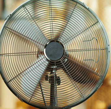 a fan on a table top with a chair