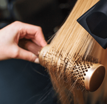 a woman is brushing her hair with a brush