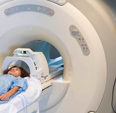 patient going inside an MRI machine with technician attending to the patient