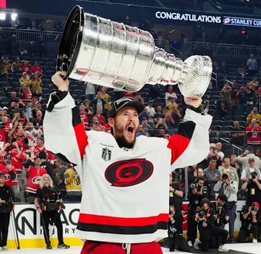 2026 Stanley Cup is held up by a Carolina Hurricanes player