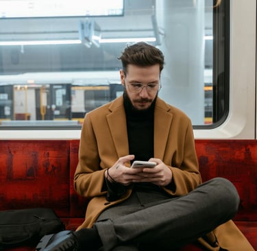 Man sitting on train holding phone