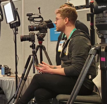 Dain Evans in a black jacket with a camera