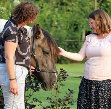 claudia en klant die bij het bruin witte paard staan