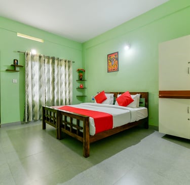 Interior view of a luxurious suite at Karapuzha Resorts, showcasing a comfortable king-sized bed, el