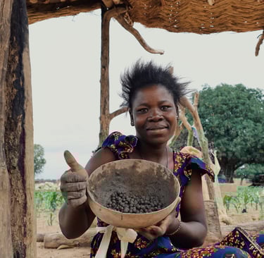 A young african lady holding a calabash full of seeds