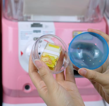seseorang membuka kapsul gacha dari mesin gashapon