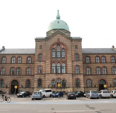 Historic brick building with a dome at the University of Copenhagen, symbolizing its commitment