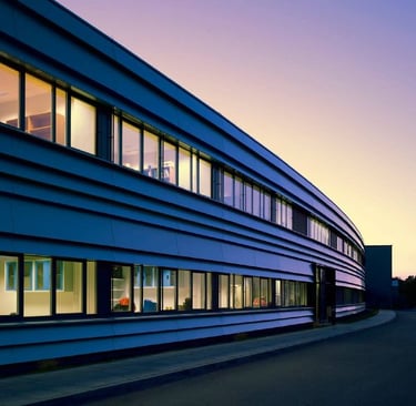 Helmholtz Centre for Environmental Research building at twilight with illuminated windows and orange