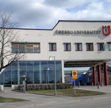 Exterior view of Örebro University building with glass facade and prominent logo