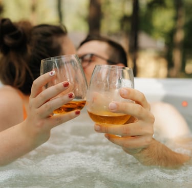 a couple of people in a hot tub drinking whiskey