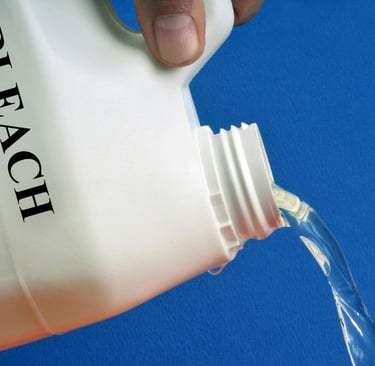 a person pouring a bottle of bleach