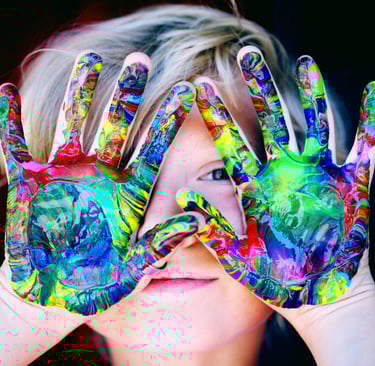 Un enfant joyeux en art-thérapie avec des mains colorées pour créer son œuvre d'art