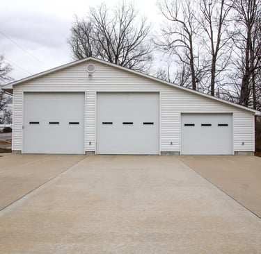 A fire station with 3 garage doors and a flag pole