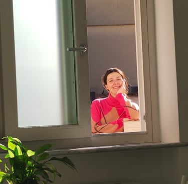 Giusy smiling through the window of the new home in Amalfi, in the first days