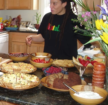 a woman standing in front of a counter top with a variety of food