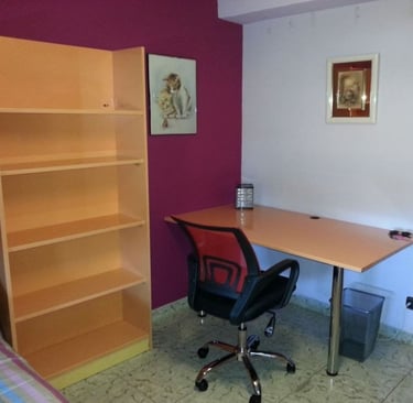 Habitación con estantería y amplio escritorio
