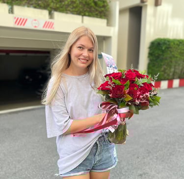 a woman holding a bouquet of red roses